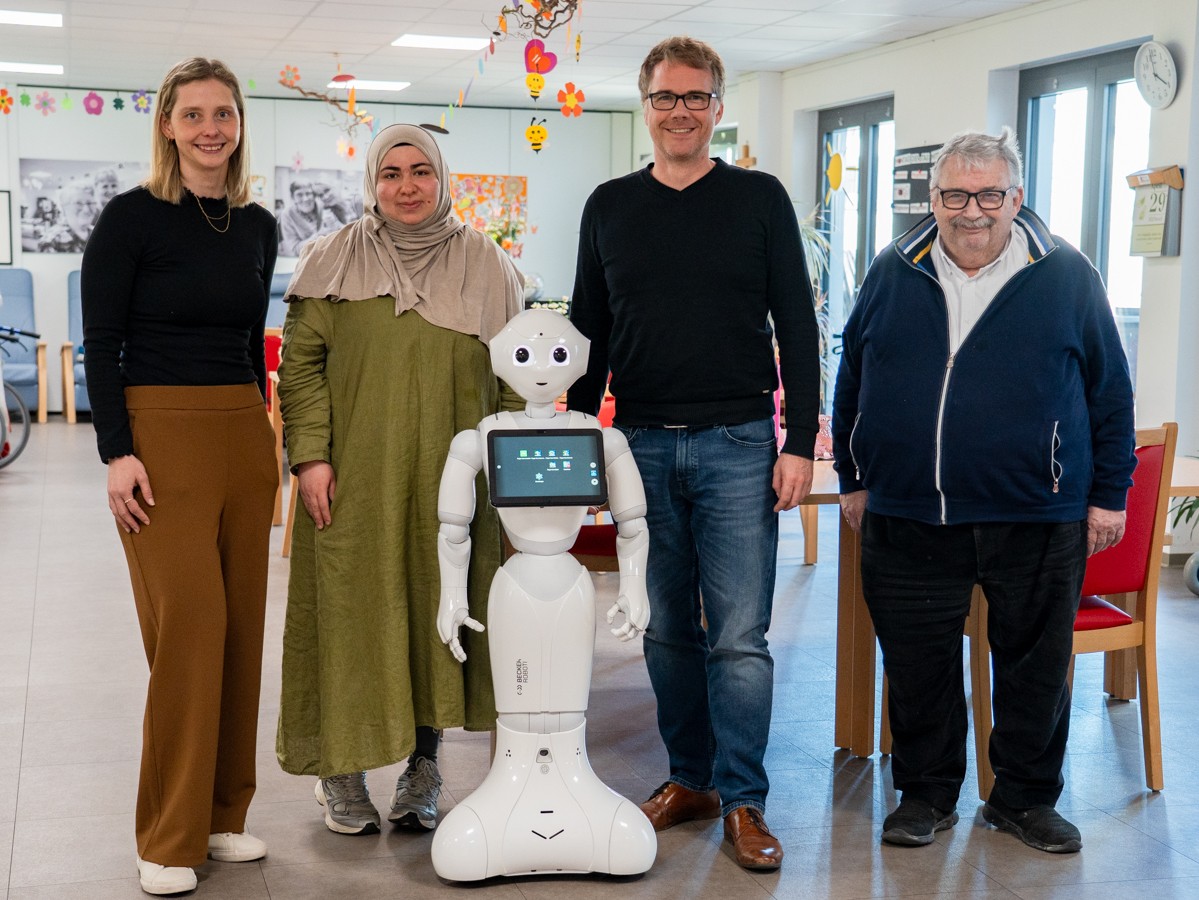 Gruppenbild mit den beiden KiPf-Teammitgliedern, einer Pflegekraft und dem Vorstand der Sozialstation und Roboter Pepper