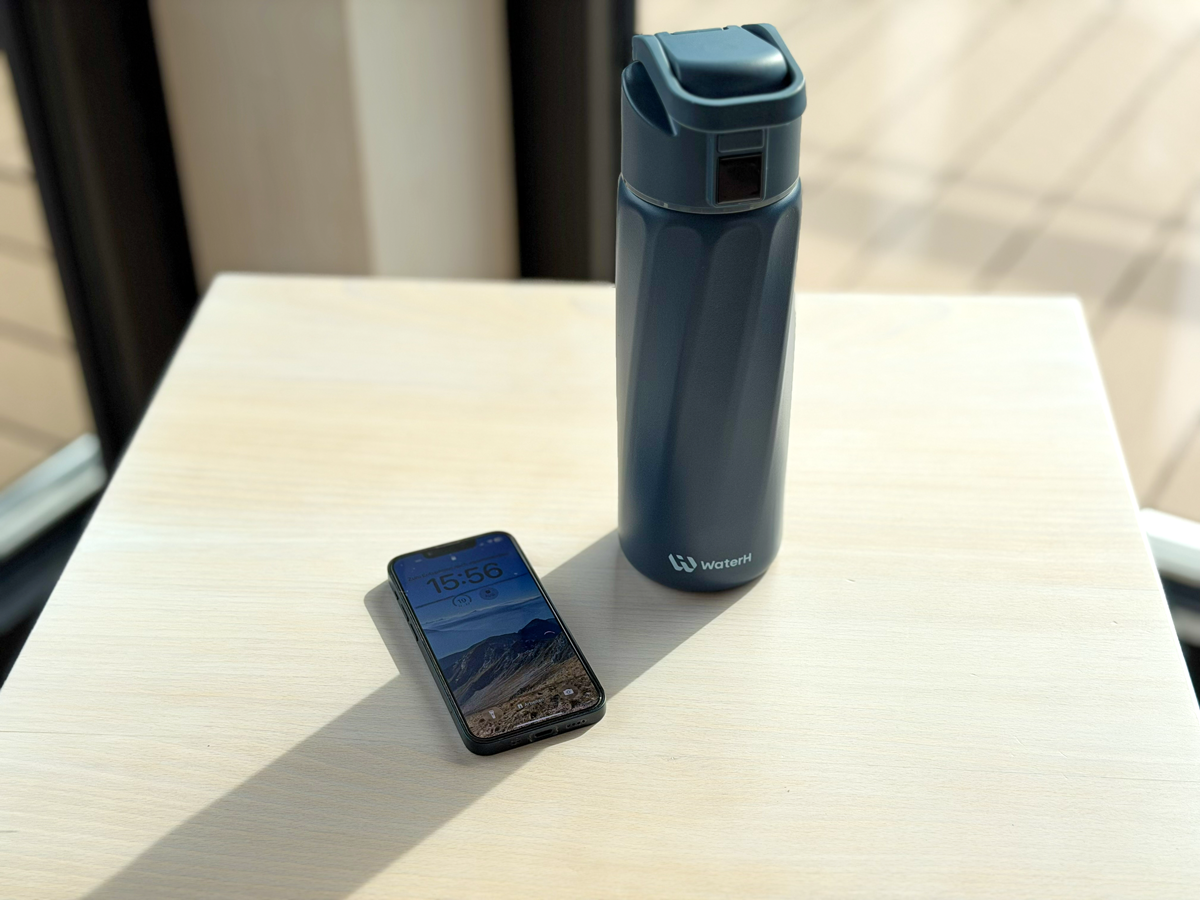 Smarte Trinkflasche mit Smartphone daneben