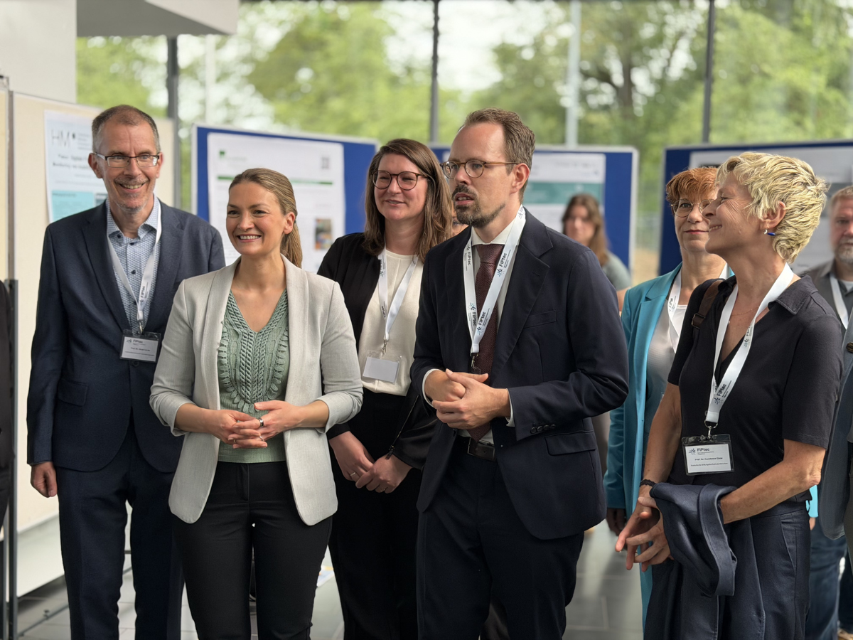 Die Ministerin und andere Gäste sehen sich die Ausstellung an.