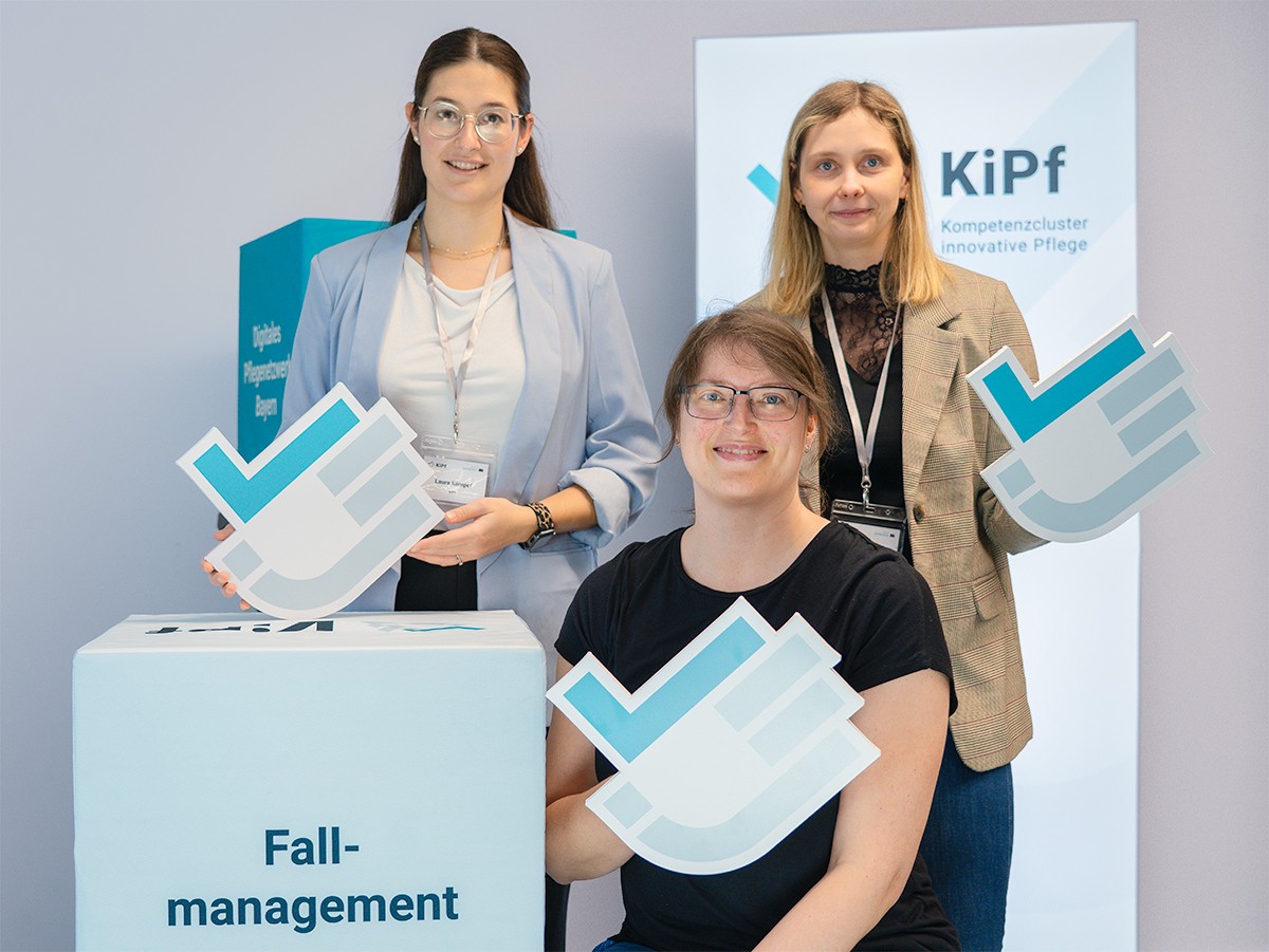 KiPf Mitarbeiterinnen mit KiPf Logo in den Händen