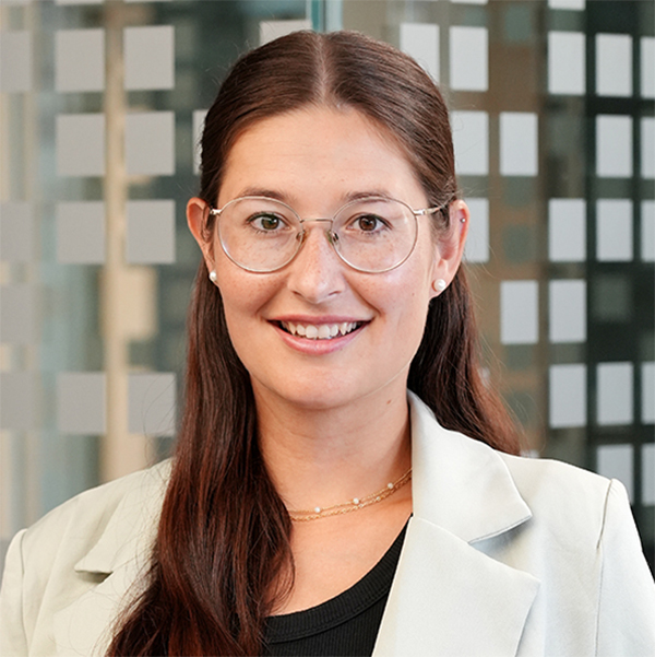Porträtfoto von Laura Kömpel. Junge Frau mit Brille, langen braunen Haaren, braunen Augen.
