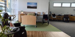 Aufstehsessel und Pflegebett und Rollstühle in der Musterwohnung