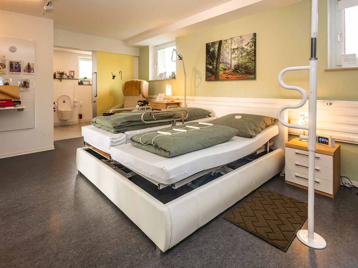 Pflegedoppelbett und diverse Aufstehhilfen in der Musterwohnung