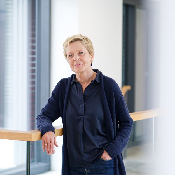 Porträtfoto von Prof. Dr. Constanze Giese. Ältere Frau mit kurzen hellblonden Haaren. Trägt blaue Ohrringe, einen blauen Cardigan mit blauer Bluse und Jeans.