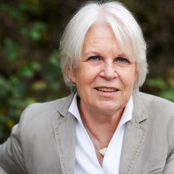 Porträtfoto von Brigitte Bührlen. Ältere Frau mit weißen mittellangen Haaren und blauen Augen.